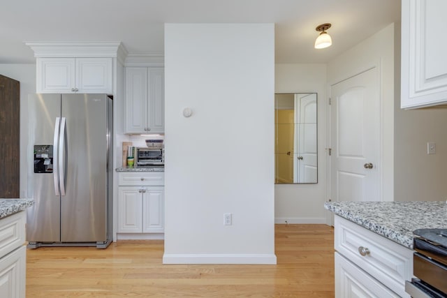 37 Highland Ave Unit 4, Derry, NH 03038 - kitchen featuring stainless steel fridge, light wood-type flooring, light stone countertops, white cabinets, and baseboards
