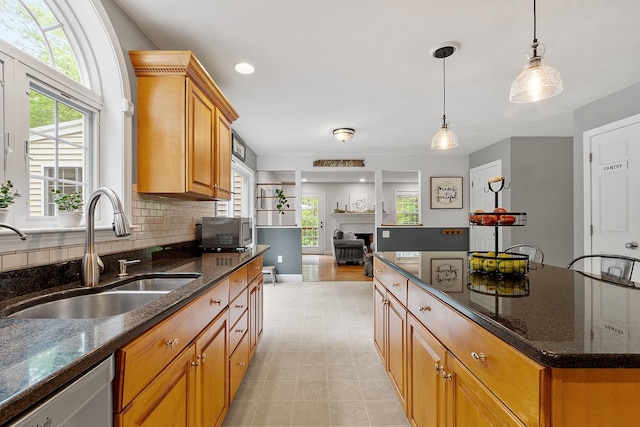24 Stonewall Dr, Milford, NH 03055 - kitchen with a sink, dishwasher, hanging light fixtures, backsplash, and dark stone countertops