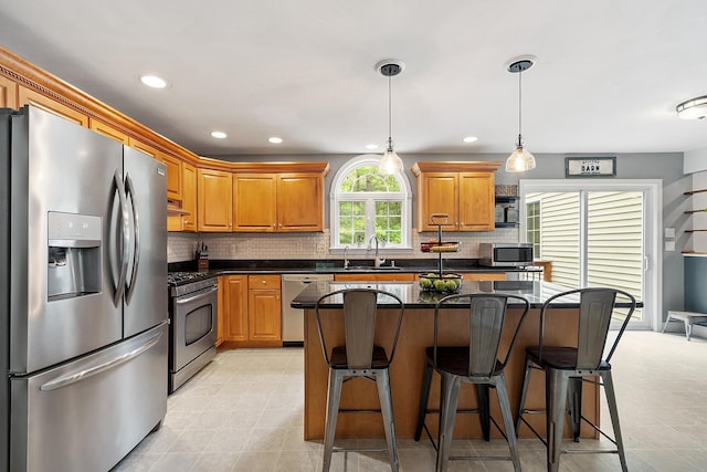 24 Stonewall Dr, Milford, NH 03055 - kitchen with appliances with stainless steel finishes, a kitchen bar, decorative backsplash, a sink, and recessed lighting