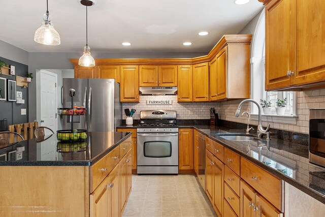 24 Stonewall Dr, Milford, NH 03055 - kitchen with stainless steel appliances, under cabinet range hood, a sink, dark stone counters, and backsplash