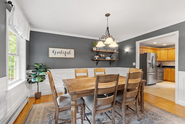 24 Stonewall Dr, Milford, NH 03055 - dining area featuring a baseboard radiator, light wood-style flooring, ornamental molding, and wainscoting