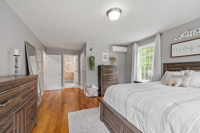 24 Stonewall Dr, Milford, NH 03055 - bedroom with a wall mounted air conditioner, light wood-style floors, and ensuite bathroom