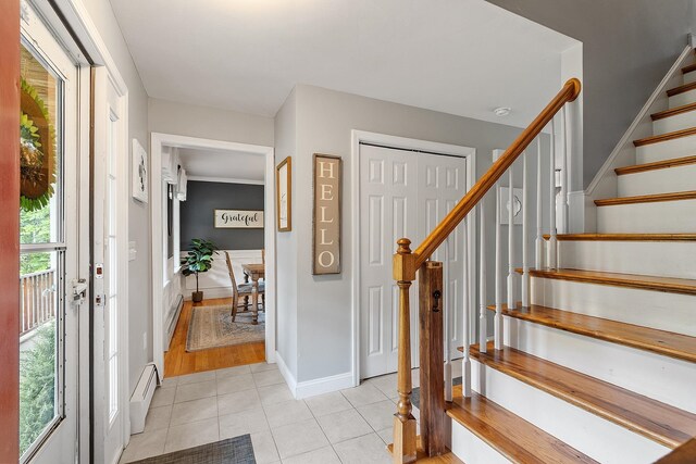 24 Stonewall Dr, Milford, NH 03055 - entrance foyer with light tile patterned floors, baseboard heating, stairs, and baseboards