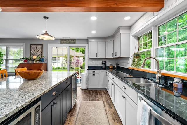 31 Henderson Rd Unit 17, Gilford, NH 03249 - kitchen featuring a sink, dark wood-style floors, stainless steel appliances, wine cooler, and backsplash