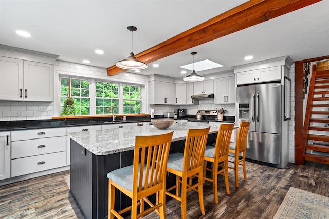 31 Henderson Rd Unit 17, Gilford, NH 03249 - kitchen with appliances with stainless steel finishes, under cabinet range hood, tasteful backsplash, dark wood-style flooring, and recessed lighting