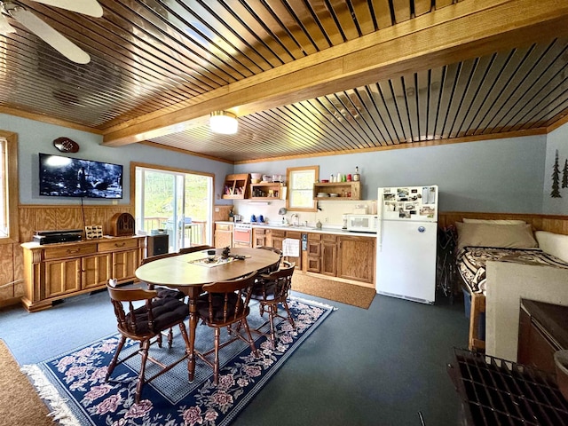 106 Philbrook Rd, Pittsburg, NH 03592 - dining area with a wainscoted wall, a ceiling fan, wooden walls, and wood ceiling with exposed beams