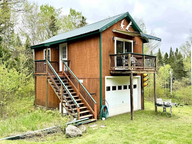 106 Philbrook Rd, Pittsburg, NH 03592 - view of front facade with a garage, metal roof, stairway, a wooden deck, and a front lawn