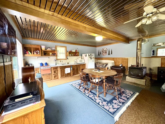 106 Philbrook Rd, Pittsburg, NH 03592 - dining room with a wood stove, carpet flooring, ceiling fan, and wooden ceiling with exposed beams