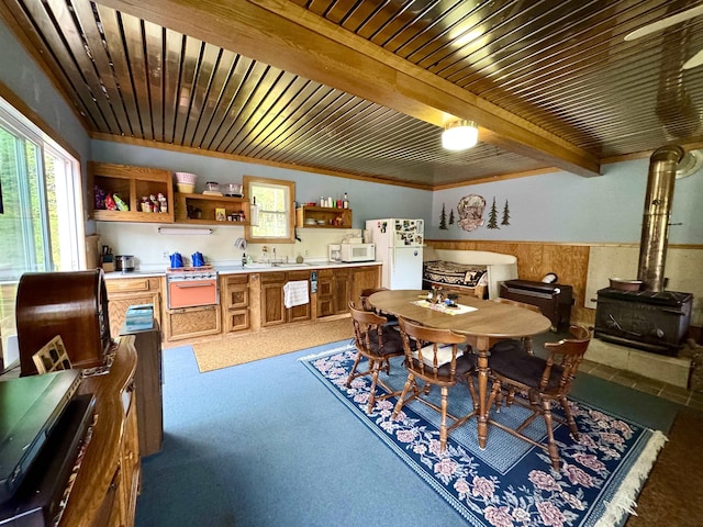 106 Philbrook Rd, Pittsburg, NH 03592 - dining room featuring bar with sink, a wood stove, wainscoting, wooden ceiling with exposed beams, and carpet