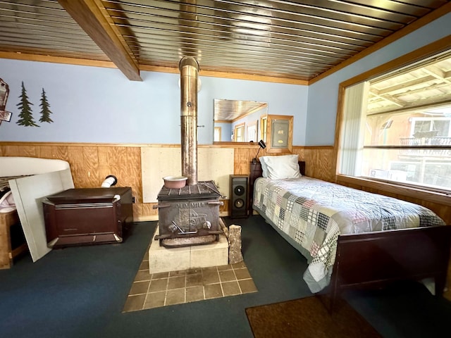 106 Philbrook Rd, Pittsburg, NH 03592 - bedroom featuring a wood stove, a wainscoted wall, and wooden walls