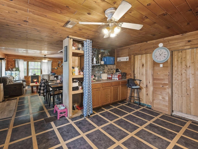 450 Leighton Corner Rd, Wakefield, NH 03872 - kitchen featuring a ceiling fan, wooden walls, wooden ceiling, brown cabinets, and open floor plan