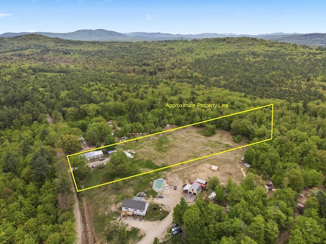 450 Leighton Corner Rd, Wakefield, NH 03872 - aerial view of property and surrounding area featuring a heavily wooded area, property parcel outlined, and mountains