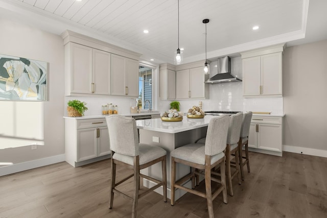 33 Little Bay Dr, Dover, NH 03820 - kitchen with wall chimney exhaust hood, a kitchen breakfast bar, a kitchen island, light countertops, and wood finished floors