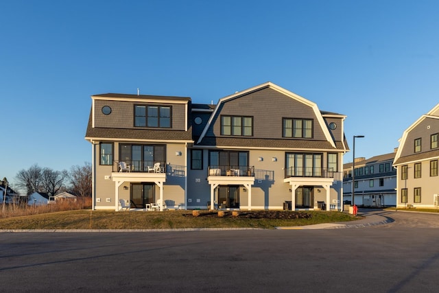 33 Little Bay Dr, Dover, NH 03820 - view of front facade with a balcony, a gambrel roof, and a shingled roof