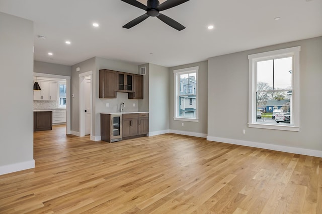 22 Little Bay Dr, Dover, NH 03820 - unfurnished living room featuring wine cooler, light wood-style flooring, ceiling fan, recessed lighting, and baseboards