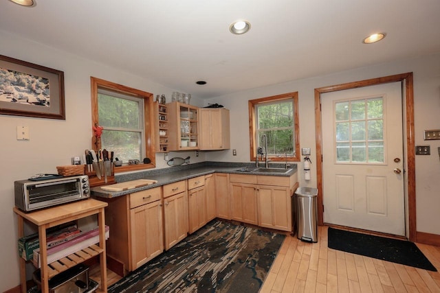 29 Isaac Frye Hwy, Wilton, NH 03086 - kitchen featuring light brown cabinets, a sink, dark countertops, wood finished floors, and glass insert cabinets