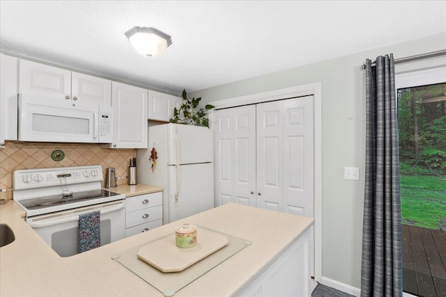 7 Daniel Plummer Rd Unit E, Goffstown, NH 03045 - kitchen featuring white appliances, white cabinets, decorative backsplash, light countertops, and baseboards