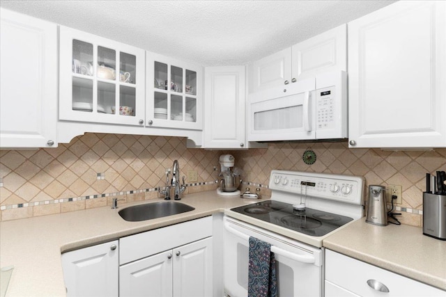 7 Daniel Plummer Rd Unit E, Goffstown, NH 03045 - kitchen with white appliances, a sink, white cabinetry, light countertops, and glass insert cabinets