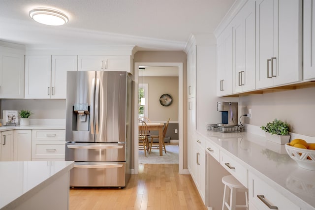 16 Pulpit Run, Amherst, NH 03031 - kitchen with stainless steel refrigerator with ice dispenser, light wood finished floors, light countertops, and white cabinets
