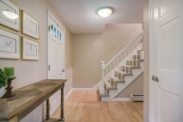 16 Pulpit Run, Amherst, NH 03031 - foyer entrance with a baseboard heating unit, wood finished floors, baseboards, and stairway