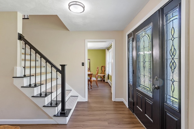 11 Woodhenge Cir, Londonderry, NH 03053 - foyer featuring wood finished floors, baseboards, and stairway