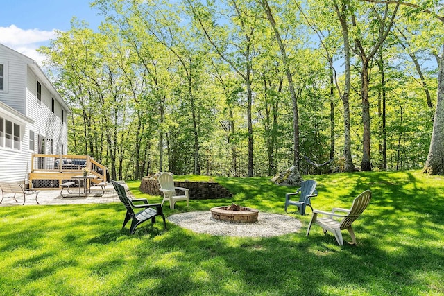 11 Woodhenge Cir, Londonderry, NH 03053 - view of grassy yard featuring an outdoor fire pit and a wooden deck