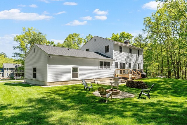 11 Woodhenge Cir, Londonderry, NH 03053 - back of property featuring an outdoor fire pit, a lawn, a deck, and a chimney