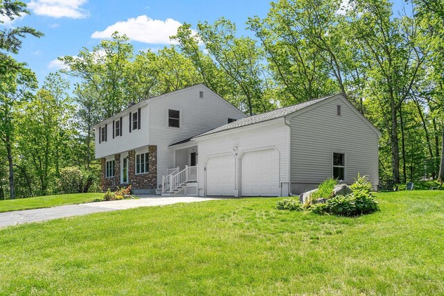 11 Woodhenge Cir, Londonderry, NH 03053 - colonial home featuring an attached garage, driveway, a front yard, and brick siding