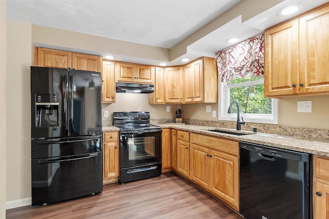 11 Woodhenge Cir, Londonderry, NH 03053 - kitchen with black appliances, a sink, under cabinet range hood, light wood-style floors, and light stone counters