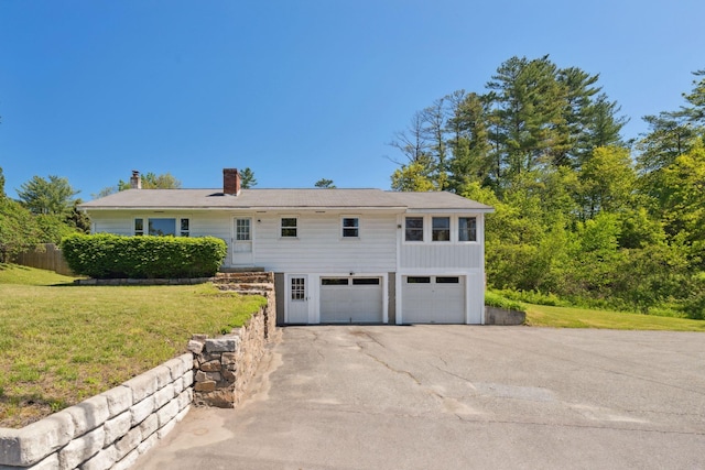 173 Mascoma St, Lebanon, NH 03766 - view of front of property featuring a chimney, asphalt driveway, a front lawn, and an attached garage