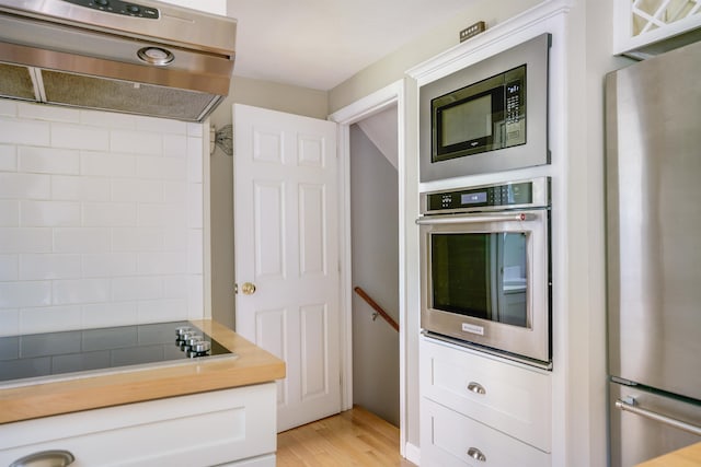 86 Pelham Rd, Salem, NH 03079 - kitchen with stainless steel appliances, exhaust hood, light wood-style flooring, white cabinets, and light countertops