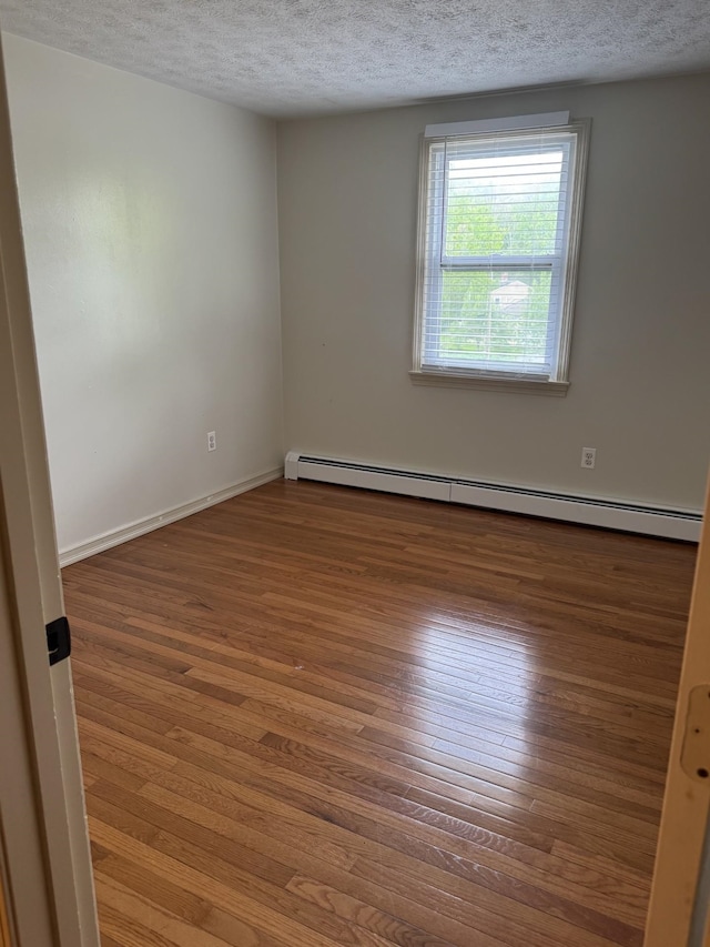 9 Quarry Rd, Hampstead, NH 03841 - empty room featuring wood finished floors, a textured ceiling, a baseboard heating unit, and baseboards