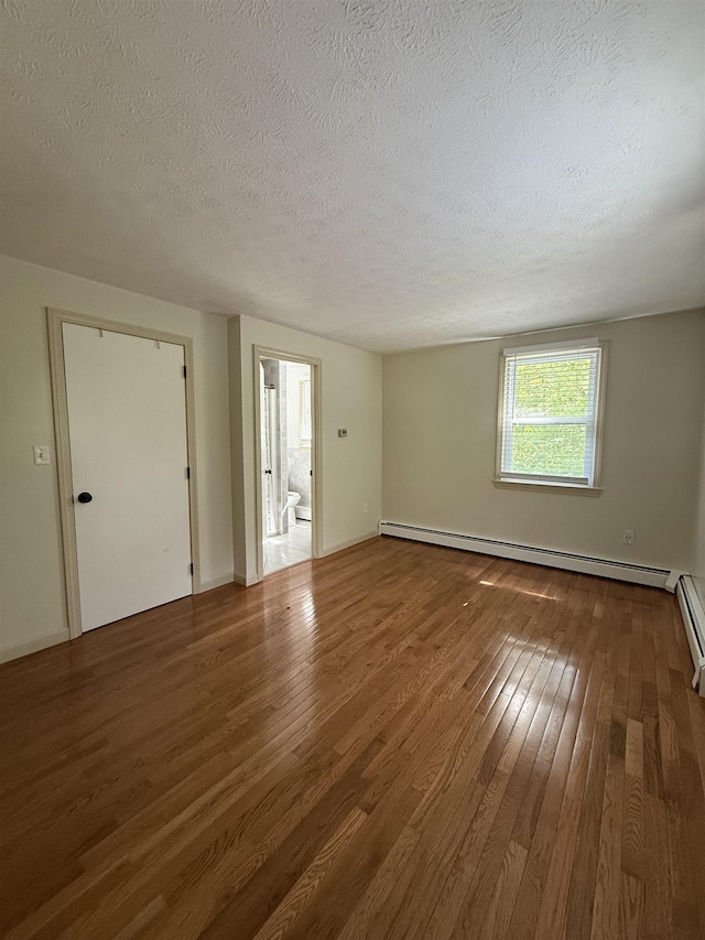 9 Quarry Rd, Hampstead, NH 03841 - spare room featuring a baseboard heating unit, wood finished floors, a textured ceiling, and baseboards