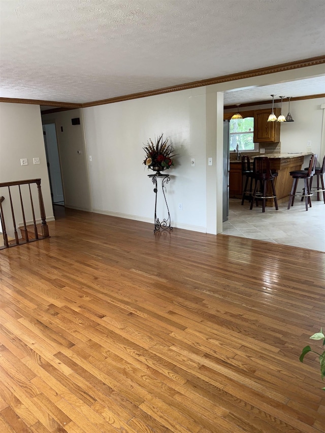 9 Quarry Rd, Hampstead, NH 03841 - unfurnished living room with light wood finished floors, ornamental molding, and a textured ceiling