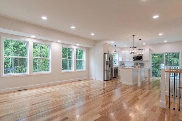 28 Colony Dr, Barnstead, NH 03225 - kitchen with stainless steel appliances, white cabinets, light countertops, light wood-type flooring, and a kitchen island