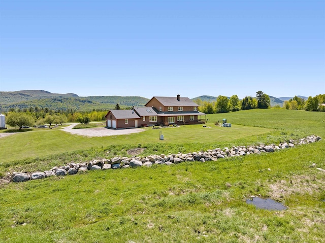 338 Johnson Rd, Marshfield, VT 05658 - view of green lawn featuring a mountain view, a garage, and driveway