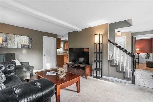 37 Level St, Merrimack, NH 03054 - living room featuring baseboards, stairway, beamed ceiling, and light colored carpet
