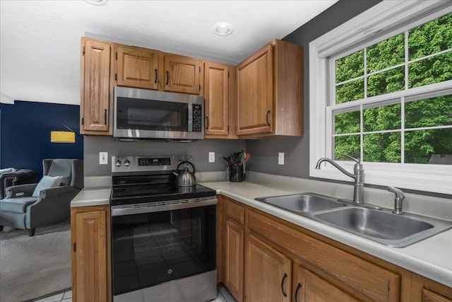 37 Level St, Merrimack, NH 03054 - kitchen featuring appliances with stainless steel finishes, a sink, light countertops, and brown cabinets