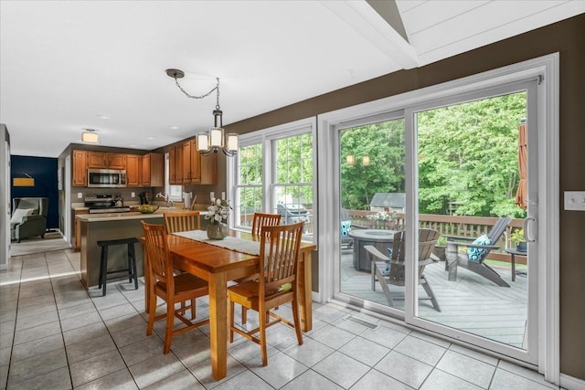 37 Level St, Merrimack, NH 03054 - dining area with healthy amount of natural light, light tile patterned floors, and a chandelier