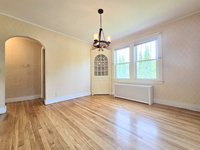 366 S Main St, Concord, NH 03301 - unfurnished dining area with radiator, ornamental molding, arched walkways, light wood-style flooring, and wallpapered walls