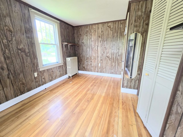 366 S Main St, Concord, NH 03301 - spare room featuring radiator, baseboards, light wood-type flooring, and wooden walls