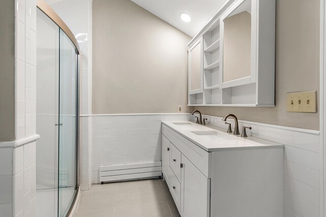 47 Blossom Rd, Windham, NH 03087 - bathroom featuring tile walls, a wainscoted wall, double vanity, a stall shower, and a baseboard heating unit