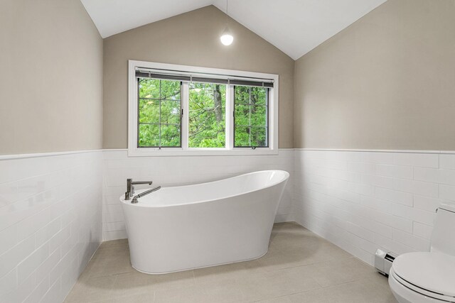 47 Blossom Rd, Windham, NH 03087 - bathroom featuring tile walls, a freestanding tub, a wainscoted wall, a baseboard heating unit, and plenty of natural light