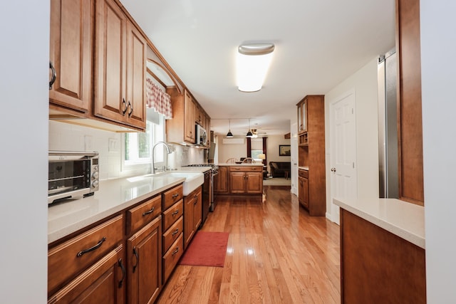 144 Whitten Rd, Milford, NH 03055 - kitchen with stainless steel appliances, light wood finished floors, decorative backsplash, and light countertops