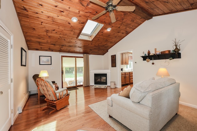 144 Whitten Rd, Milford, NH 03055 - living area with baseboard heating, wood ceiling, plenty of natural light, a ceiling fan, and a glass covered fireplace
