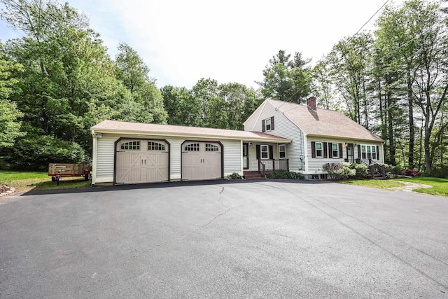 144 Whitten Rd, Milford, NH 03055 - view of front of property featuring an attached garage, a chimney, driveway, view of wooded area, and roof with shingles