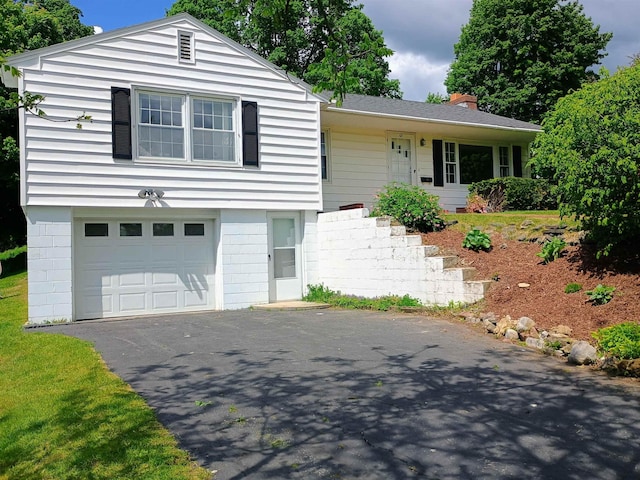 65 E Washington St, Rutland City, VT 05701 - view of front of home with a chimney, an attached garage, and asphalt driveway