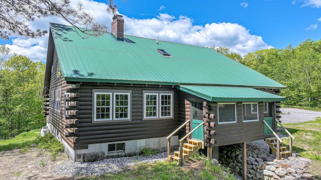 689 Hard Scrabble Rd, Sweden, ME 04008 - cabin with log exterior, a chimney, entry steps, and metal roof