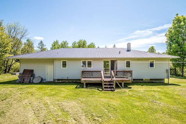 1351 Bobbin Mill Rd, Lunenburg, VT 05906 - back of property with metal roof, a wooden deck, a lawn, and a chimney