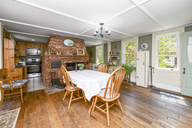 31 Main St, Sandown, NH 03873 - dining space featuring hardwood / wood-style flooring, a chandelier, a brick fireplace, and baseboards